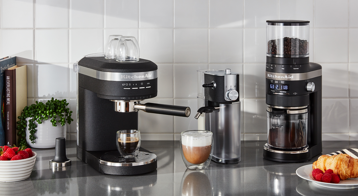 Homemade latte between KitchenAid® Semi-Automatic Espresso Machine and KitchenAid® burr coffee grinder