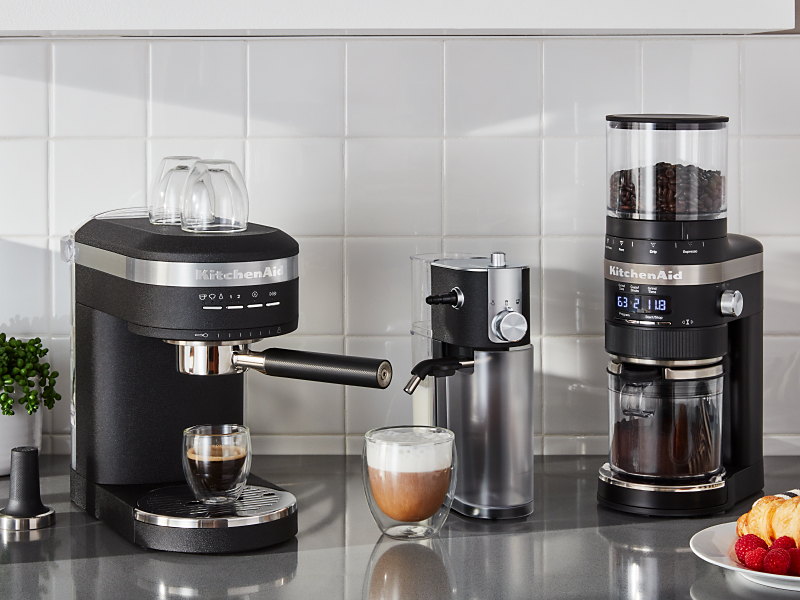 Homemade latte between KitchenAid® Semi-Automatic Espresso Machine and KitchenAid® burr coffee grinder