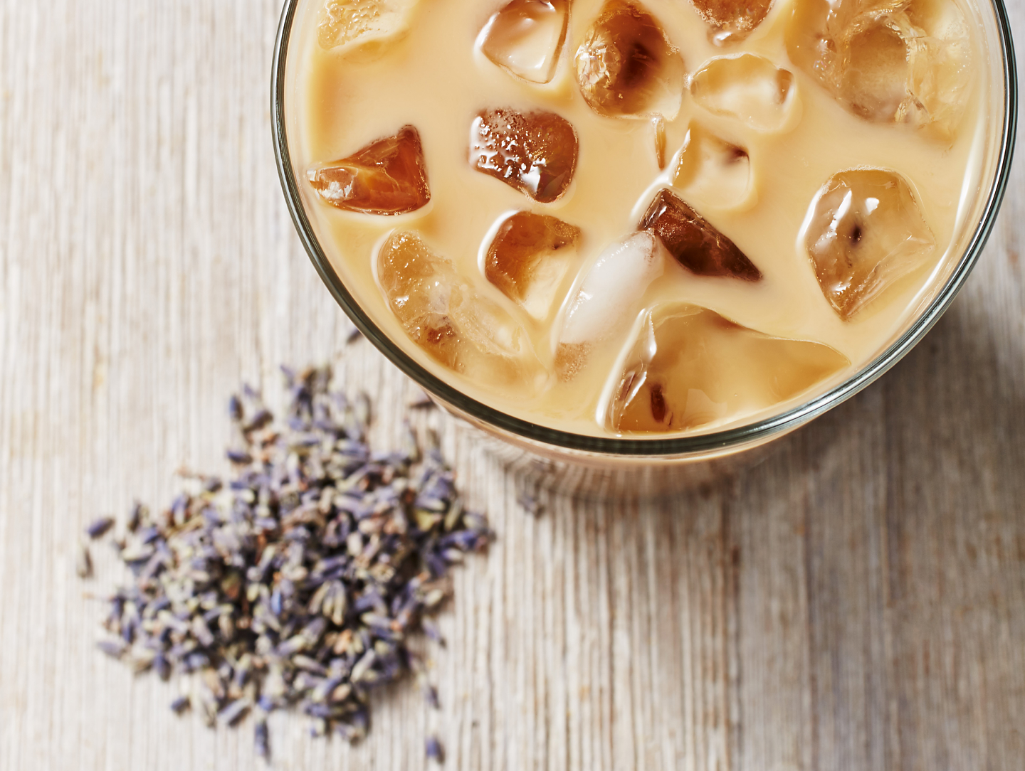  Iced coffee drink with fresh lavender buds on countertop
