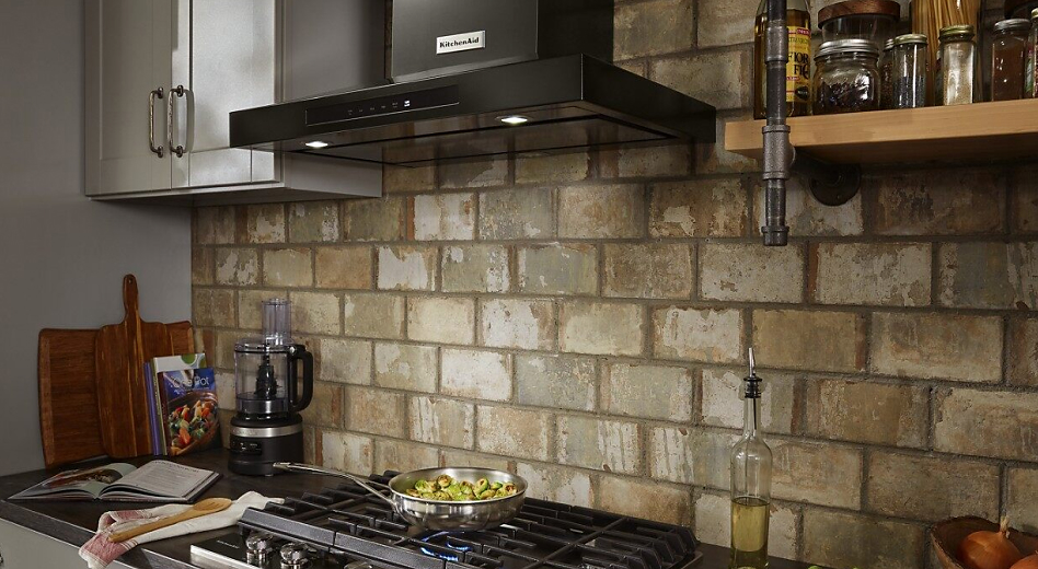 KitchenAid® range hood in kitchen with brick backsplash