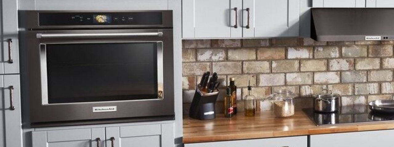 A built-in microwave featured in a clean, fully stocked kitchen.