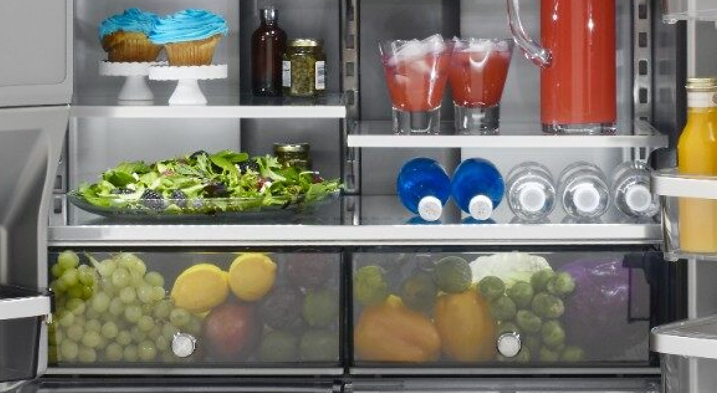 Interior of french door refrigerator with fresh ingredients and bottled beverages