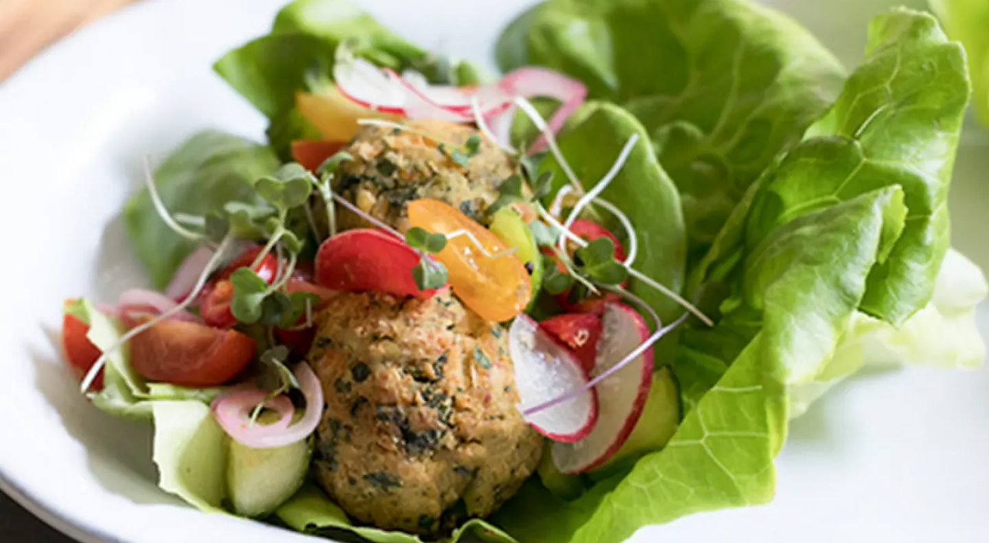 Close-up of salad with lettuce topped with radish, falafel and veggies