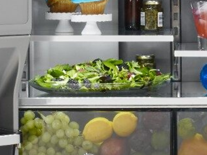 Interior of french door refrigerator with fresh ingredients and bottled beverages