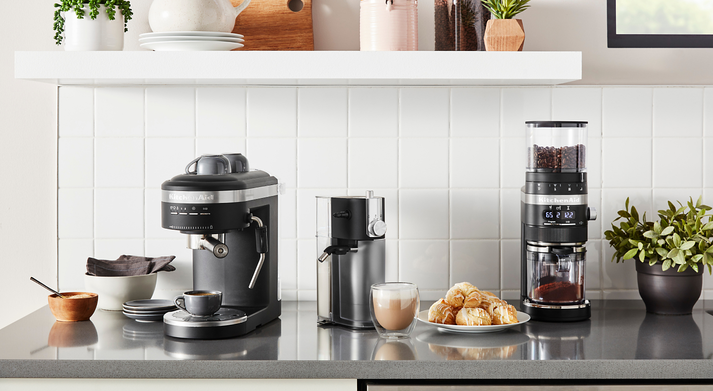 Coffee-making appliances from KitchenAid brand on counter with scones