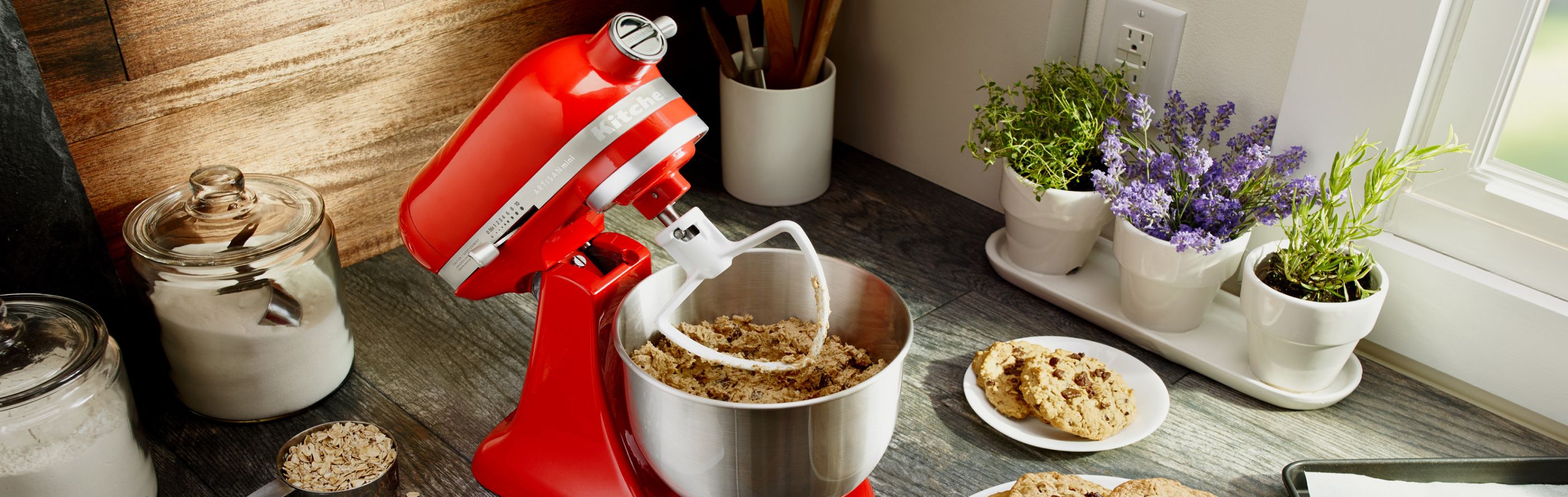 A red KitchenAid® stand mixer used to mix dough for chocolate chip cookies 