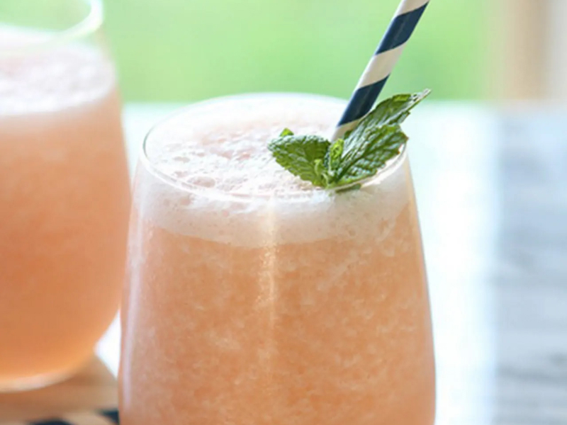Frozen citrus cocktails with mint garnish and blue and white straws