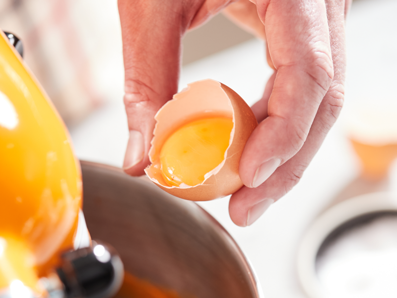 A person separating egg whites from the yolks.