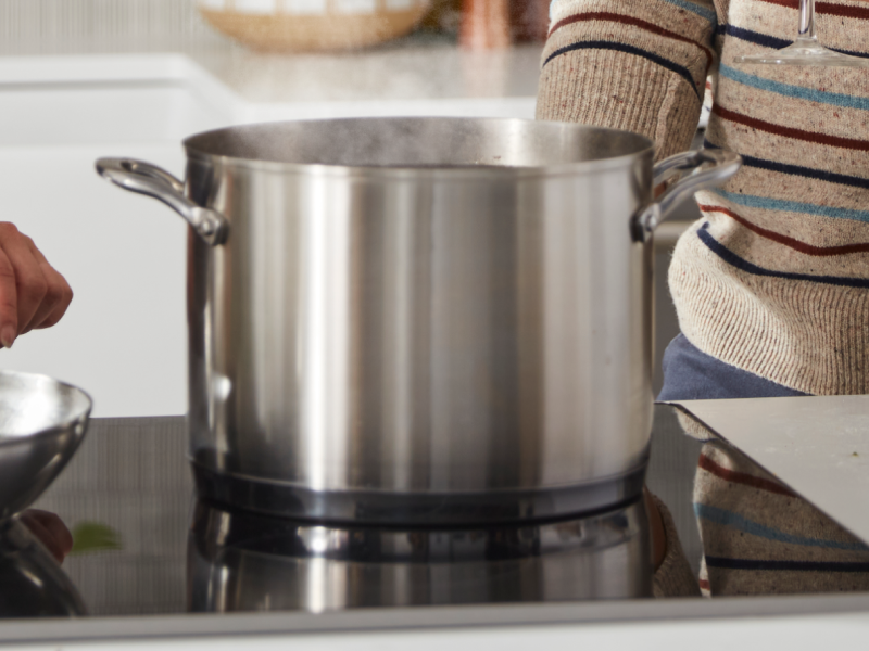 A large pot of steaming, boiling water on a KitchenAid® electric stovetop.