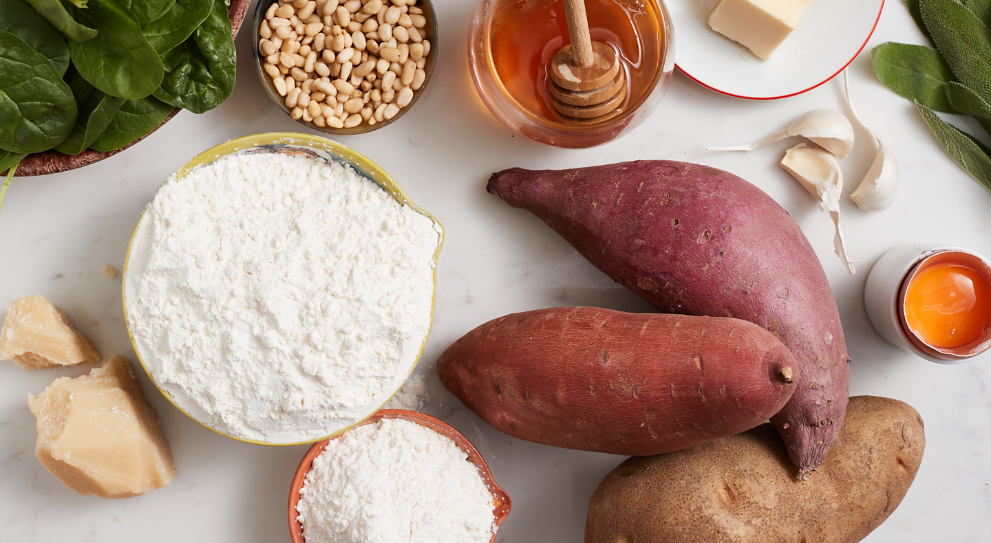 A kitchen counter with the ingredients for a sweet potato gnocchi recipe.