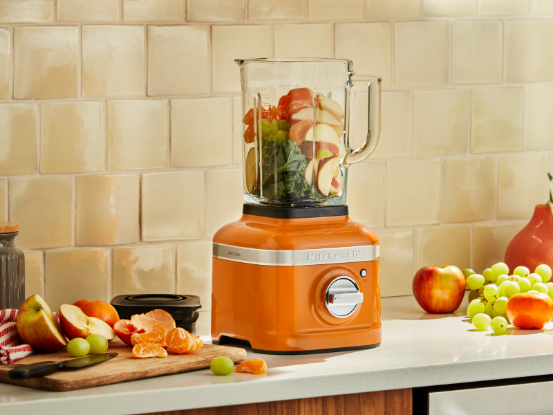 Orange KitchenAid® blender with produce inside