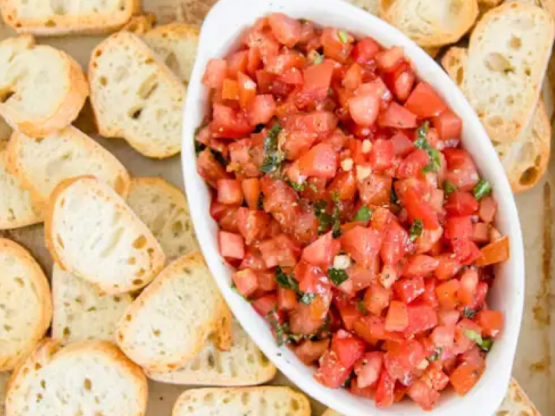 Bruschetta mixed in a bowl, ready to top bread.