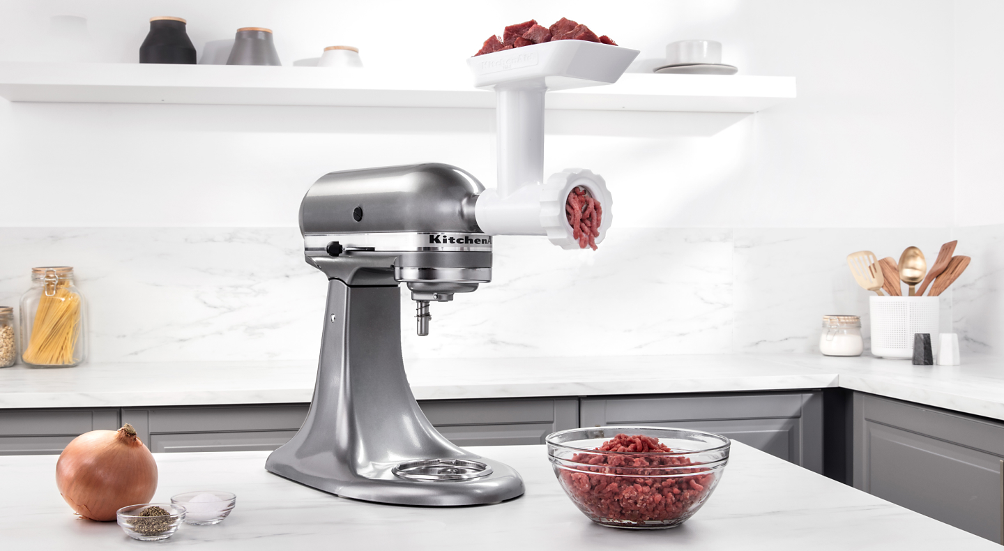 Silver KitchenAid® stand mixer with Meat Grinder Attachment grinding beef