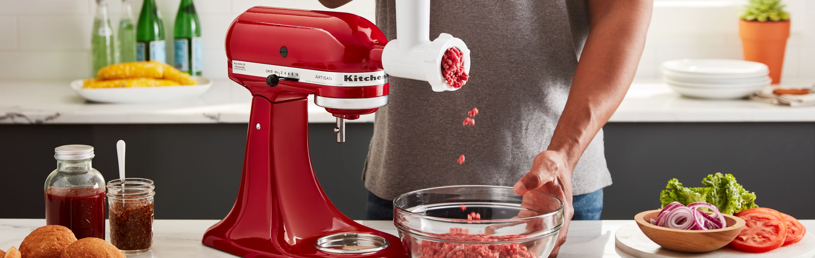 Red KitchenAid® stand mixer with Meat Grinder Attachment grinding beef