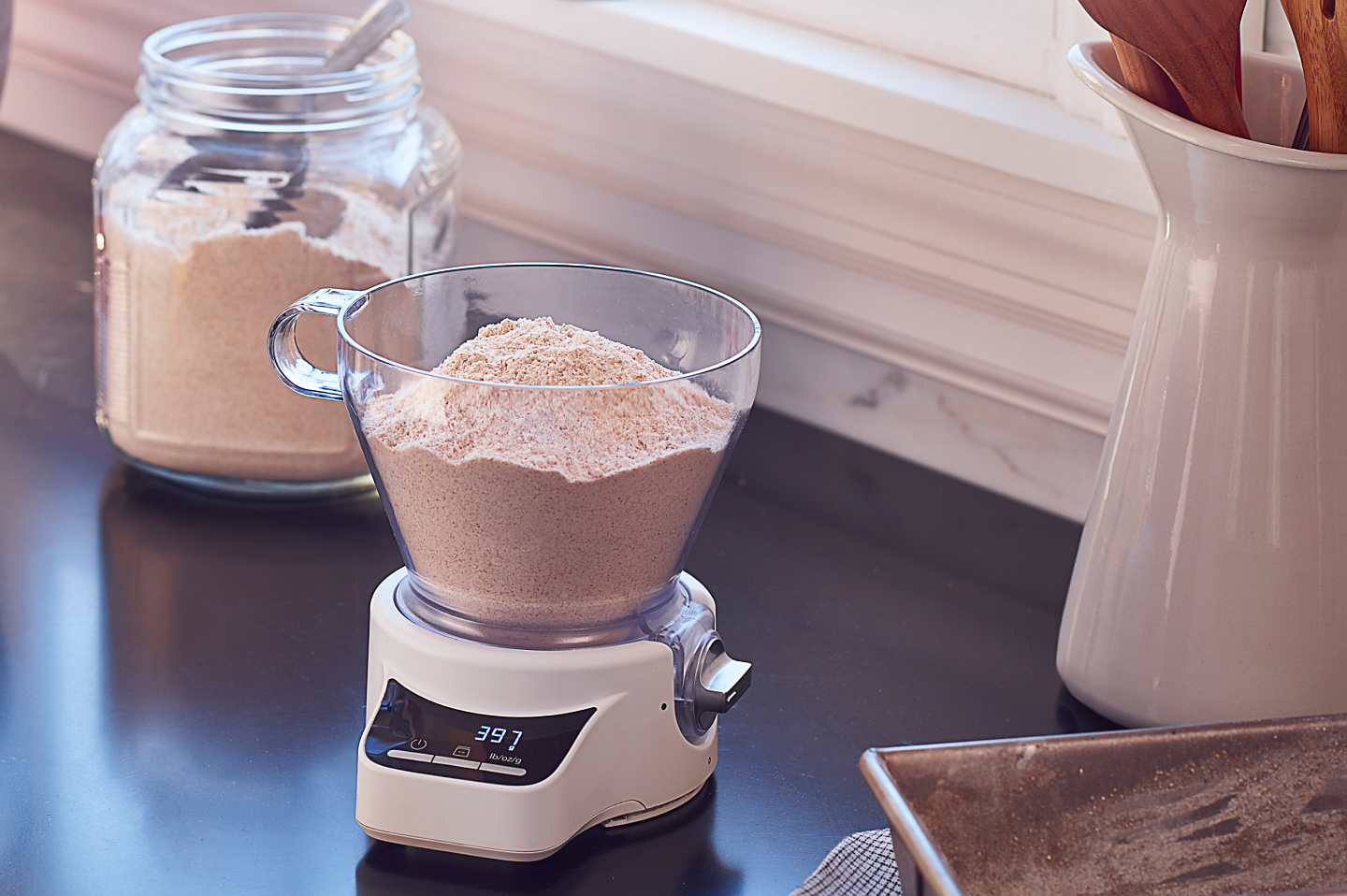KitchenAid® Sifter + Scale Attachment sitting on countertop full of flour