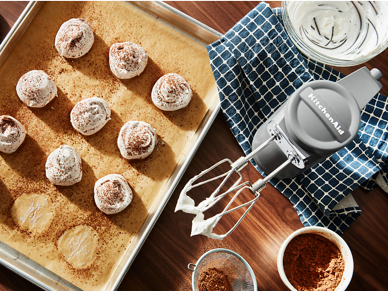 KitchenAid® hand mixer and meringue on a cookie sheet