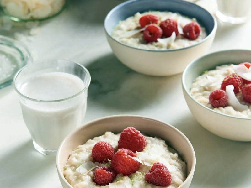 Bowls of lime coconut rice porridge with raspberries.