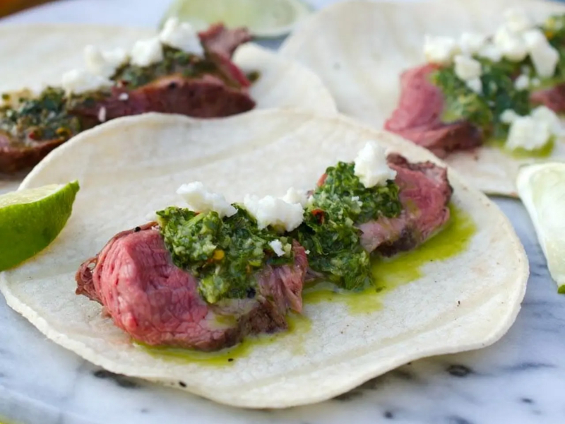 Steak tacos topped with chimichurri
