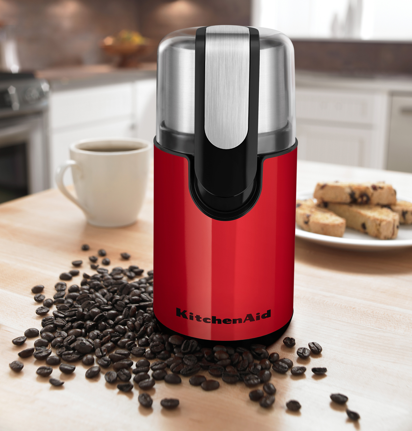 Red coffee grinder on a countertop with beans
