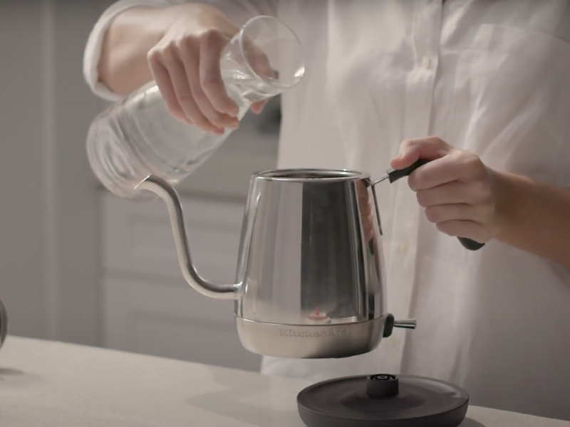 Maker pouring water into stainless steel KitchenAid® gooseneck kettle
