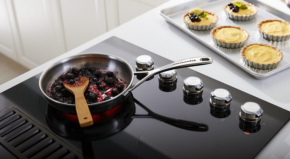 Berries cooking on a glass island cooktop 