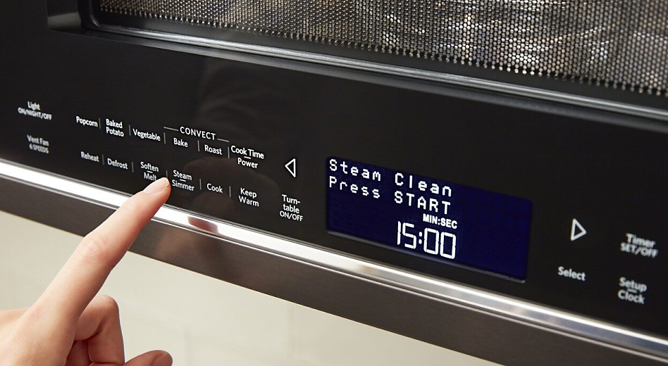 Finger touching microwave control panel
