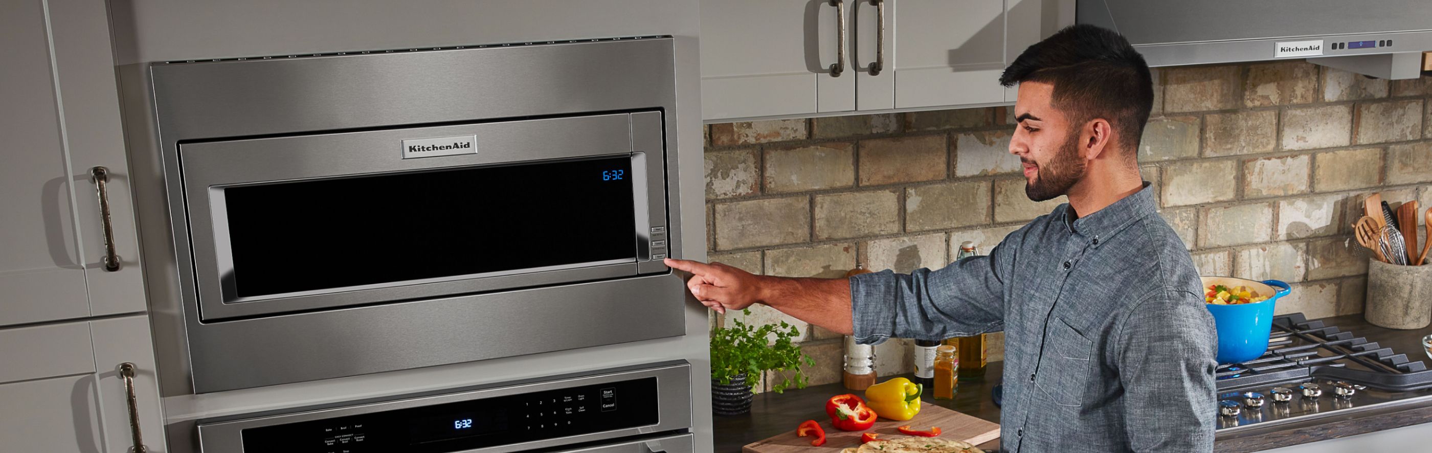 Man pointing at a KitchenAid® Built-In Microwave