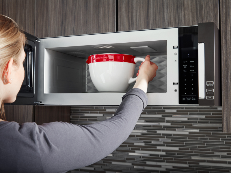Person removing bowl from microwave