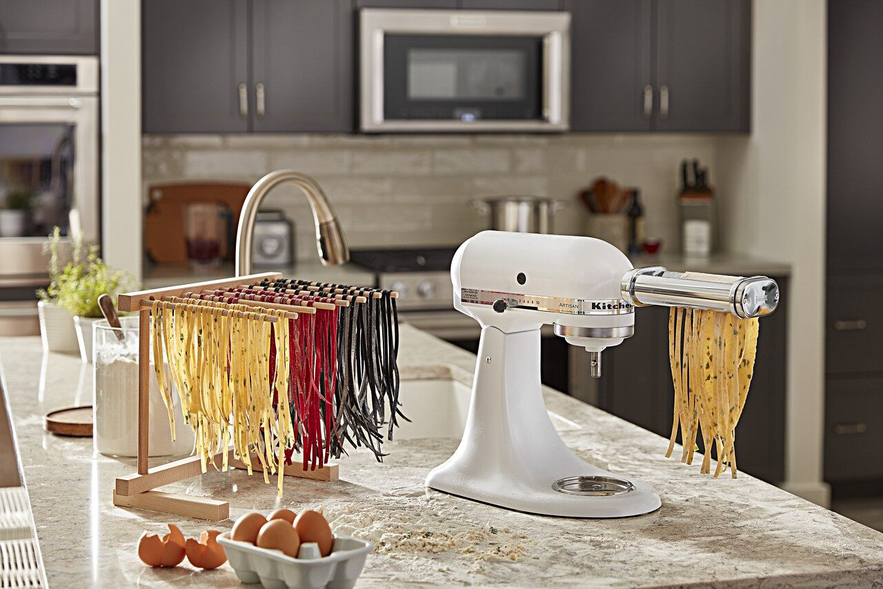 Pasta attachment on white stand mixer cutting noodles