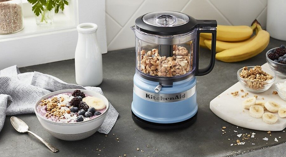 Blue food processor filled with nuts
