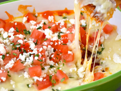 Queso fundido dip in green bowl