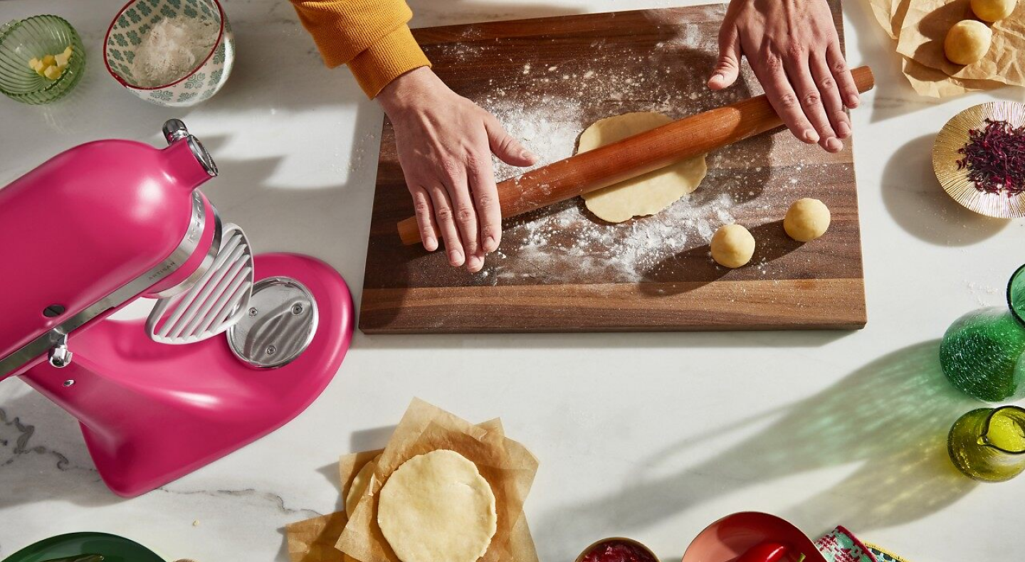 Person rolling tortilla dough on wooden cutting board