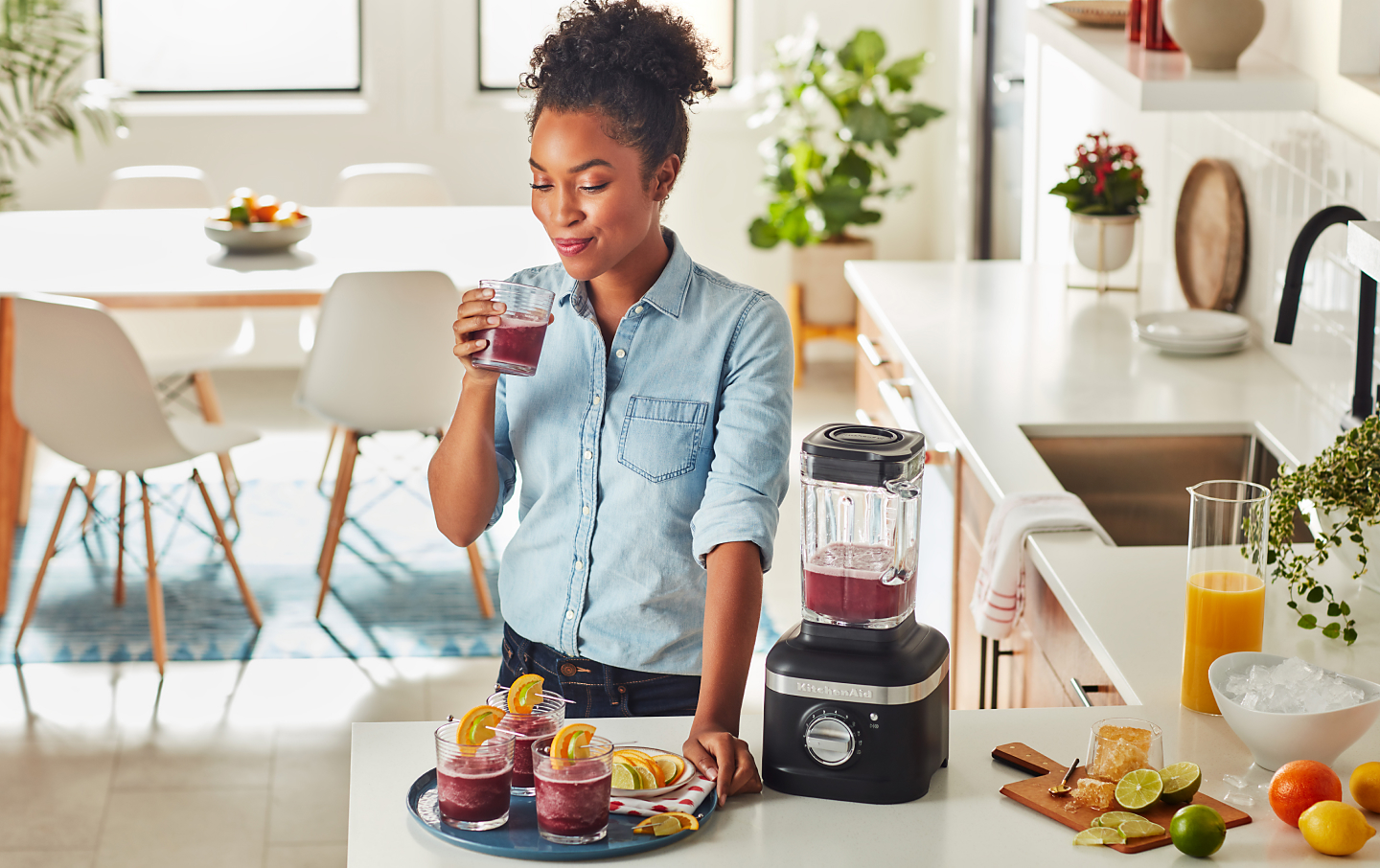 Person with KitchenAid® blender and frozen cocktails