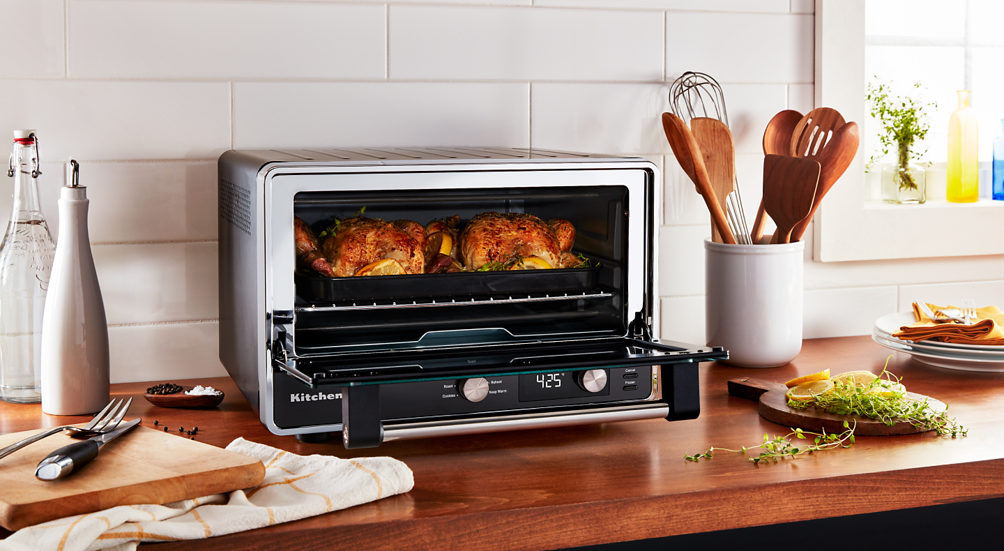 Two whole chickens roasting in a KitchenAid® countertop oven