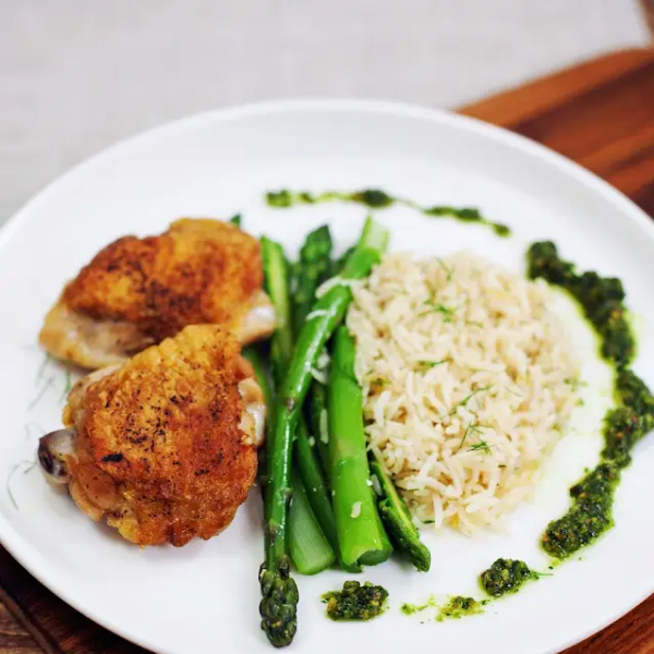 Chicken, asparagus and freekah on a plate.