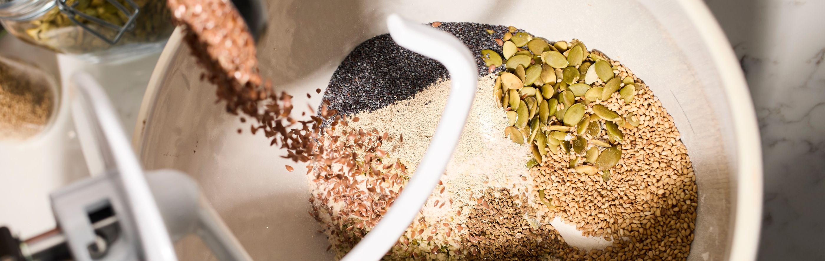 Grains being added to a KitchenAid® stand mixer.