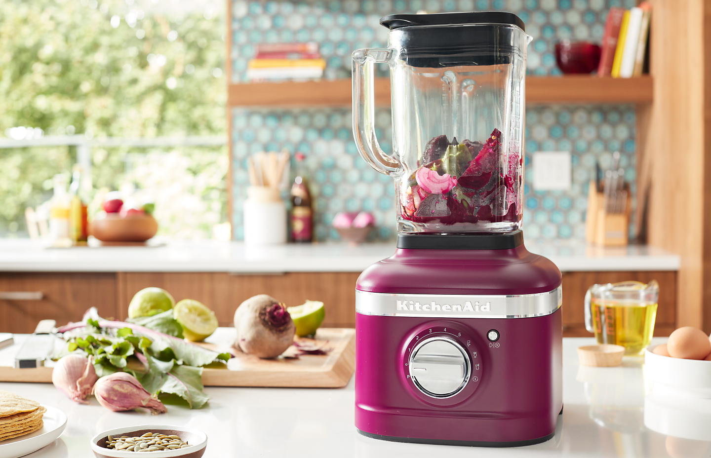 A KitchenAid® blender with fresh vegetables in a modern kitchen.