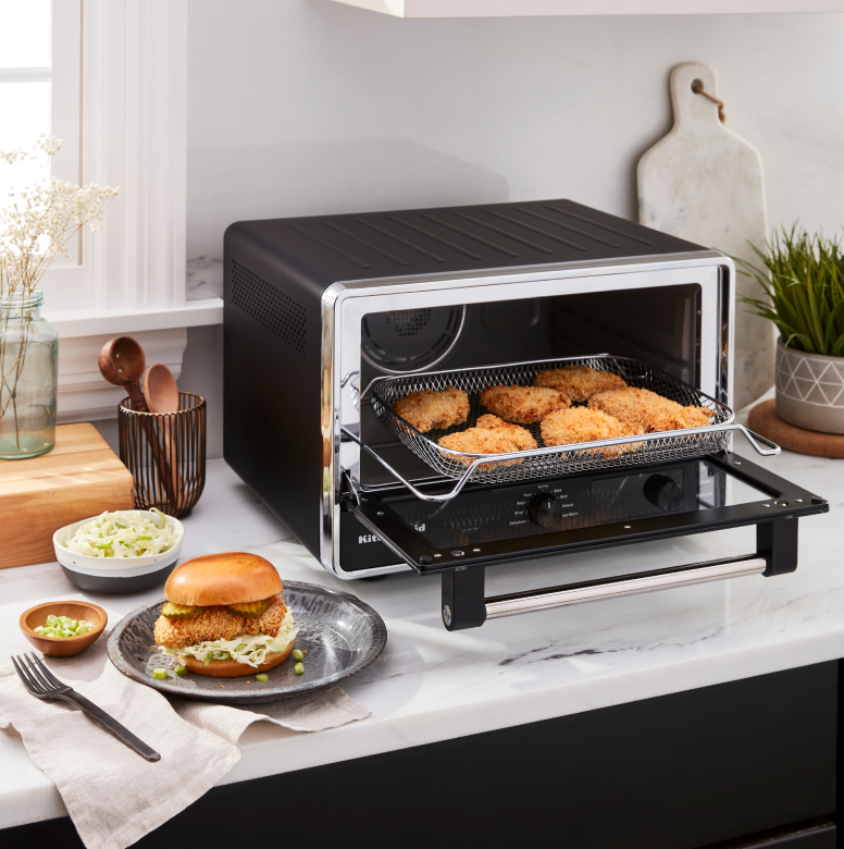 A KitchenAid® countertop oven preparing chicken patties for sandwiches.