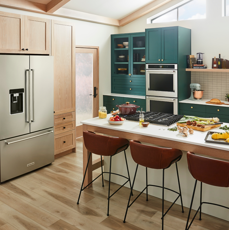 A trendy kitchen with teal cabinetry and a suite of KitchenAid® appliances.