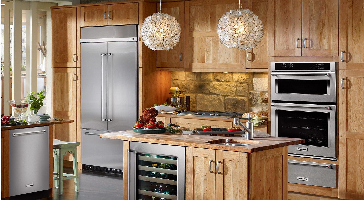 Stainless steel french door refrigerator built into a rustic wooden kitchen