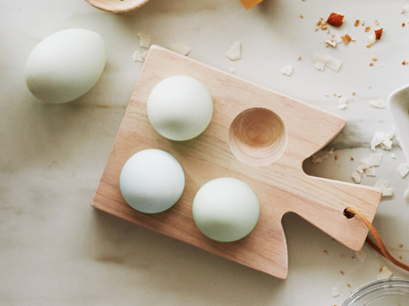 Four eggs on a wooden platter