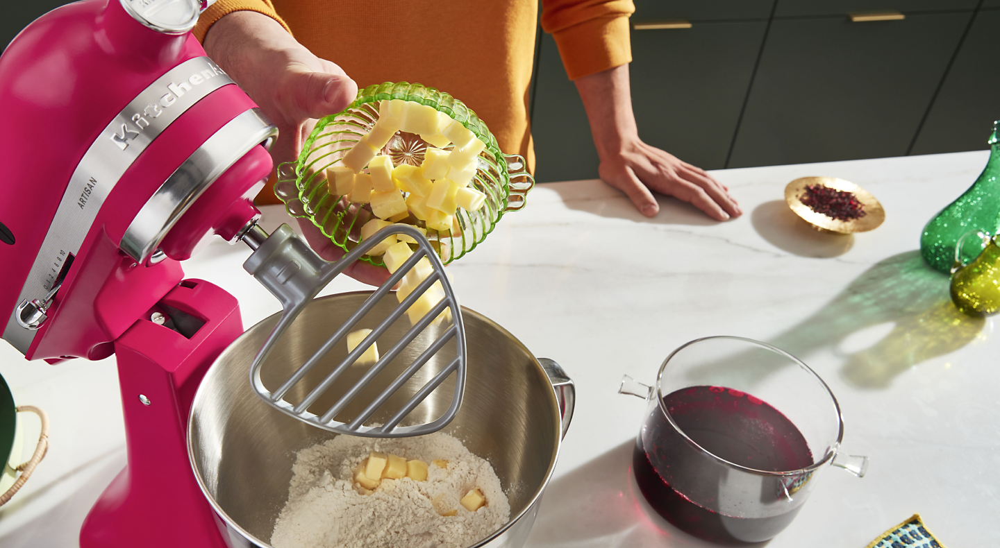 Person adding butter into a KitchenAid® stand mixer