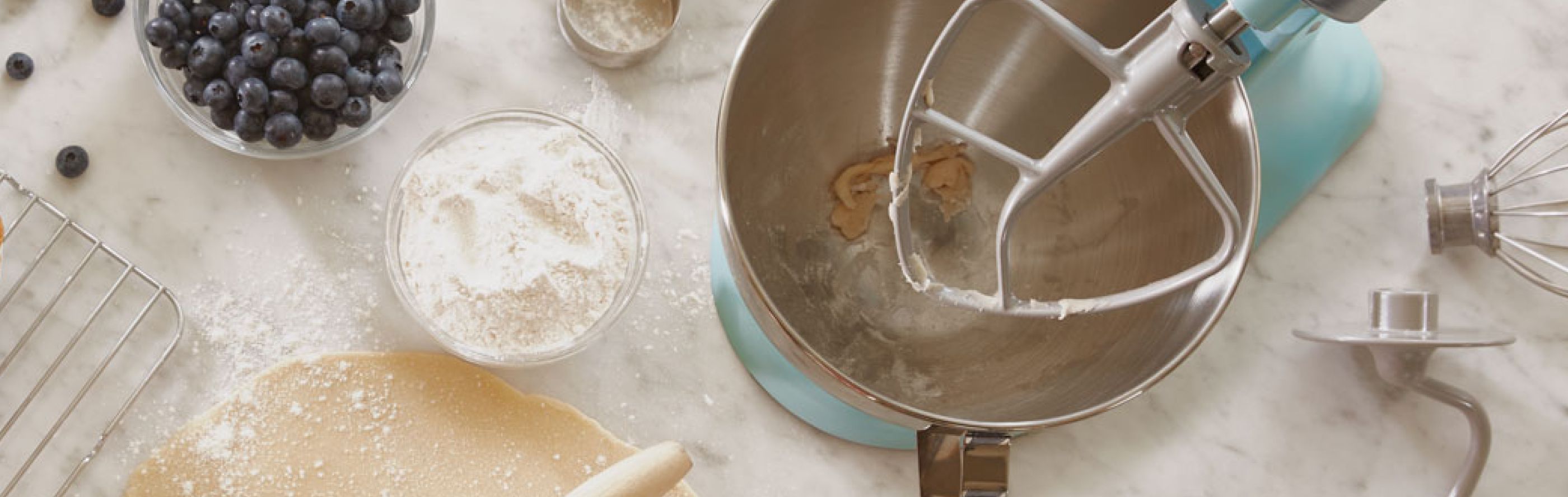 Blue KitchenAid® stand mixer next to pastry ingredients