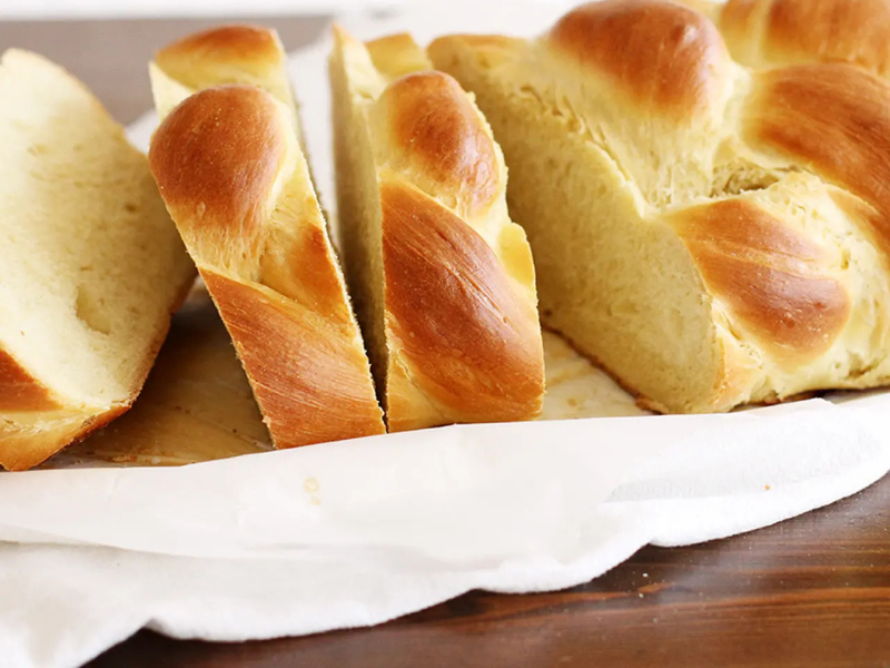 Sliced challah bread on white cloth napkin