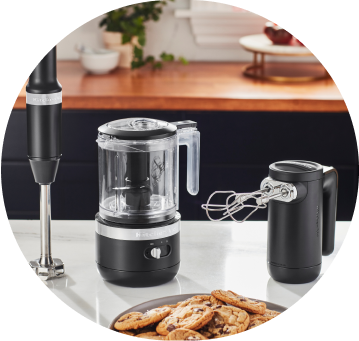Onyx Black KitchenAid® Cordless Immersion Blender, Food Chopper, and Hand Mixer on white countertop.