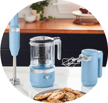 Blue Velvet KitchenAid® Cordless Immersion Blender, Food Chopper, and Hand Mixer on white countertop.