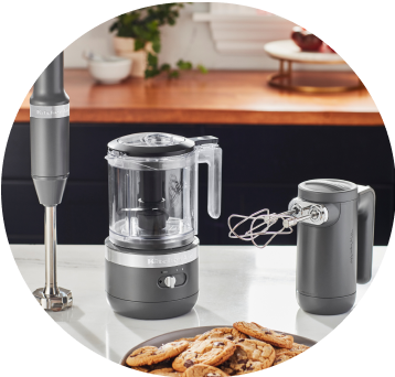 Matte Charcoal Grey KitchenAid® Cordless Immersion Blender, Food Chopper, and Hand Mixer on white countertop.