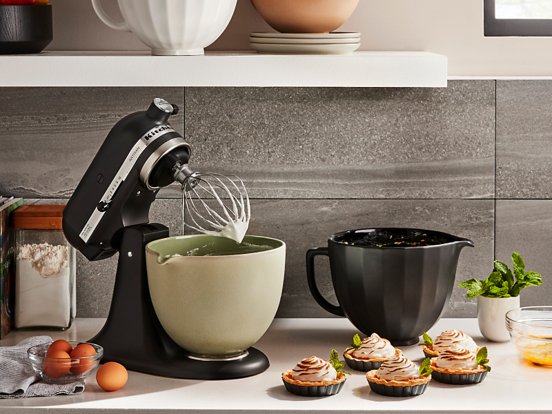 Black KitchenAid® tilt-head stand mixer next to homemade tartes