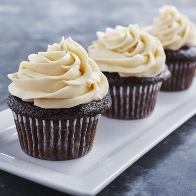 Three chocolate cupcakes topped with cream cheese frosting