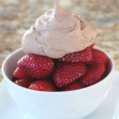 Sliced strawberries topped with chocolate whipped cream